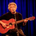 Eugenio Bennato si esibisce suonando la chitarra durante un concerto.