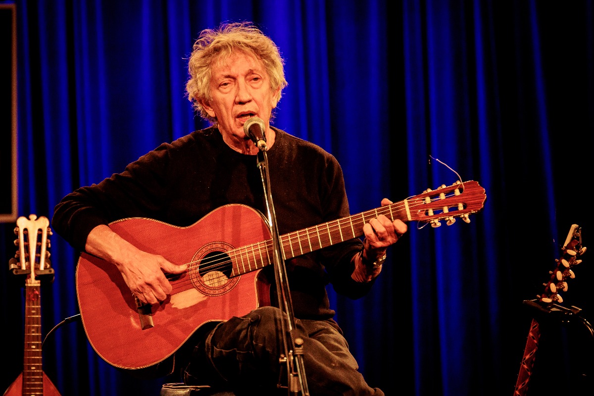 Eugenio Bennato si esibisce suonando la chitarra durante un concerto.