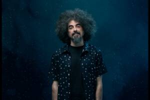 Caparezza in camicia scura con sfondo notturno
