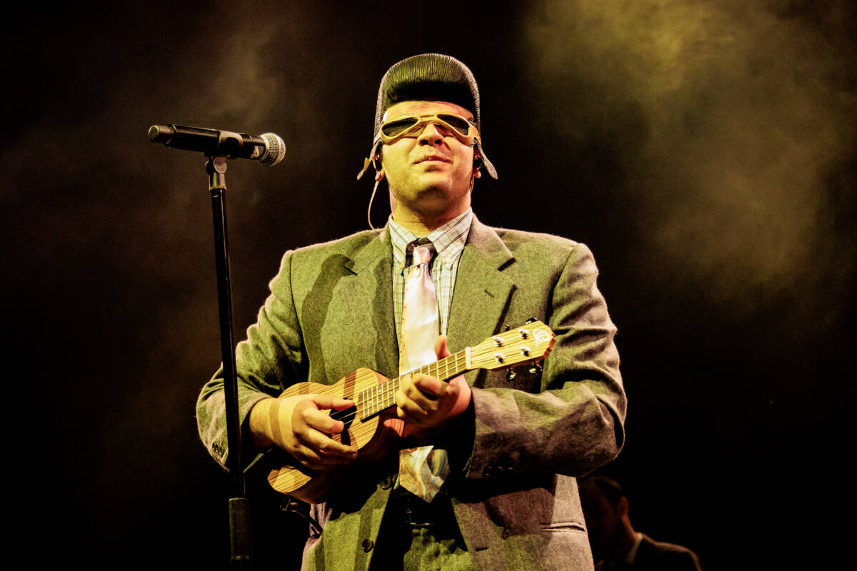 Tony Pitony in abito chiaro che suona