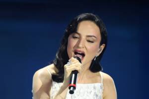 Arisa che canta in abito bianco