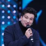 Eddie Brock in abito blu e dolcevita nero