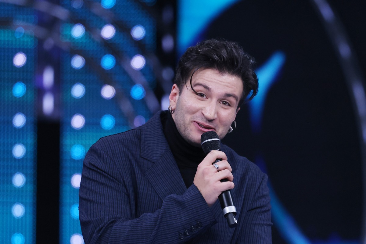 Eddie Brock in abito blu e dolcevita nero